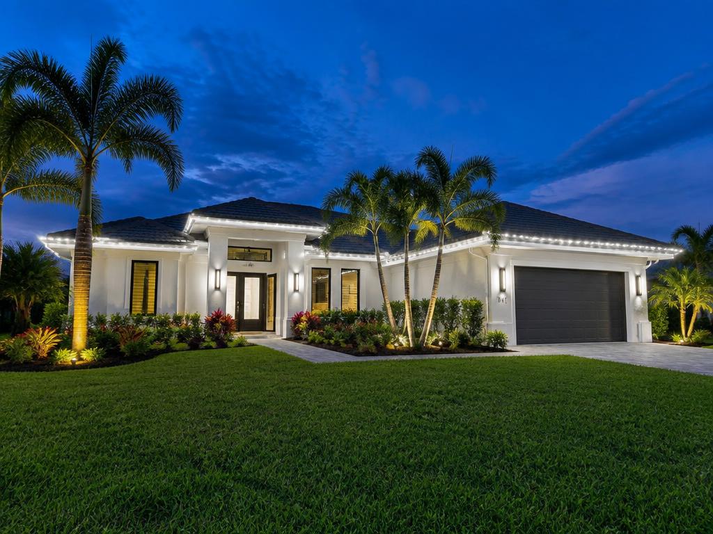 Permanent white roofline lighting on a Florida home at dusk